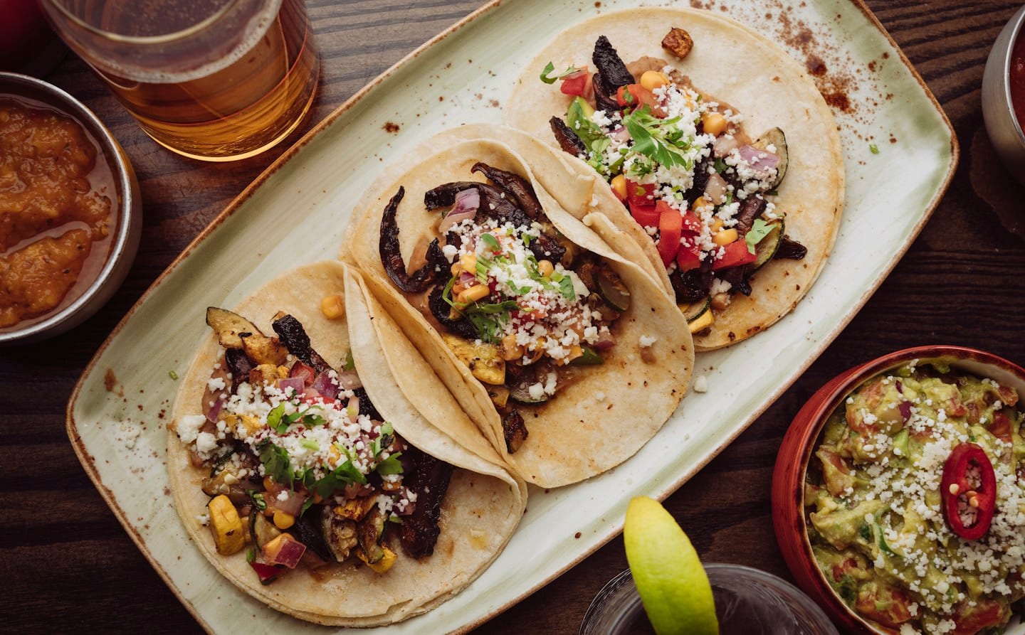 Three tacos on a restaurant plate; illustrative food photography.